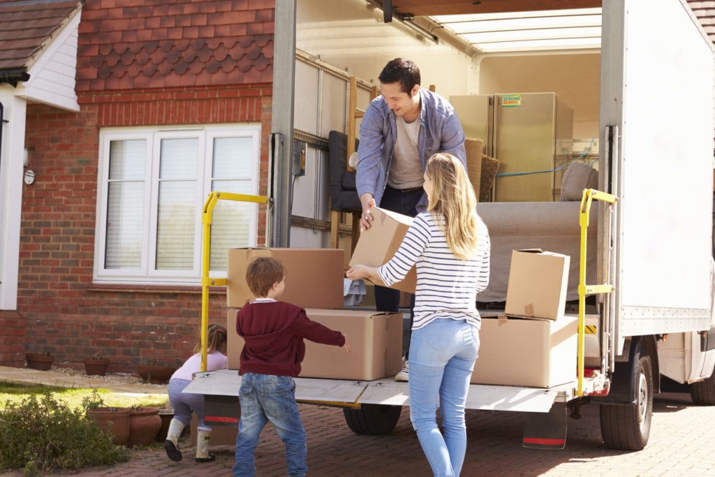 family of 3 packing a moving truck with boxes